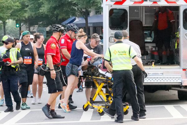Medics assist a runner that collapsed during the 53rd running of the Atlanta Journal-Constitution Peachtree Road Race in Atlanta on Monday, July 4, 2022. (Miguel Martinez / Miguel.MartinezJimenez@ajc.com)
