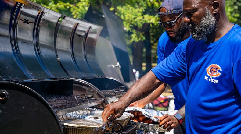 A team of vendors grill burgers and hotdogs at the Pure Heat Community Festival in Piedmont Park on Sunday, Sept. 1, 2024. (Olivia Bowdoin for the AJC).