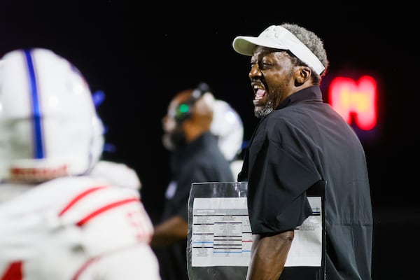 Heritage High coach Quincy Carter laughs after his team scores a a touchdown against Cedar Shoals on Friday, Aug. 21, 2026, in Athens. Carter says he had always wanted to be a coach, and that his personal trials only deepened his mission in working with young people. (Abbey Cutrer/AJC)