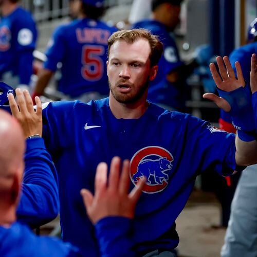 Chicago Cubs' Ian Happ is greeted in the dugout after scoring against the Atlanta Braves during the sixth inning of a baseball game, Thursday, May 14, 2026, in Atlanta. (AP Photo/Erik S. Lesser)