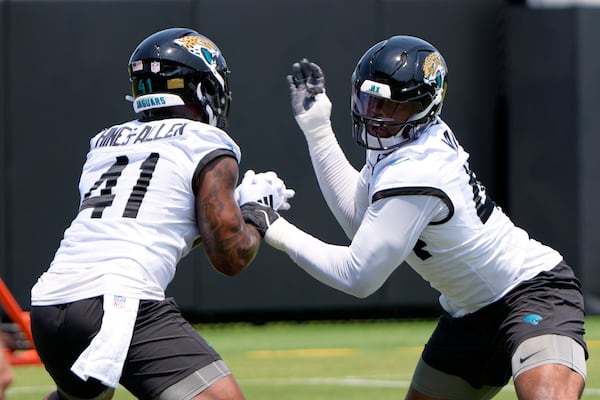 Jacksonville Jaguars defensive end Josh Hines-Allen (41) and defensive end Travon Walker, right, work on a defensive drill during a team NFL football practice, Monday, May 19, 2025, in Jacksonville, Fla. (AP Photo/John Raoux)