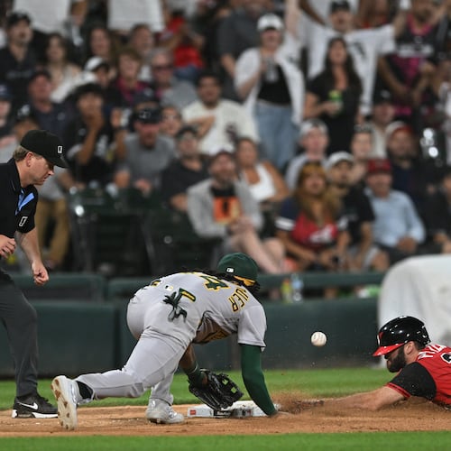 Chicago White Sox's Tristan Peters, right, slides safely into third base for an RBI triple while Athletics third baseman Joshua Kuroda-Grauer, center, catches the throw during the seventh inning of a baseball game in Chicago, Friday, July 10, 2026. (AP Photo/Paul Beaty)