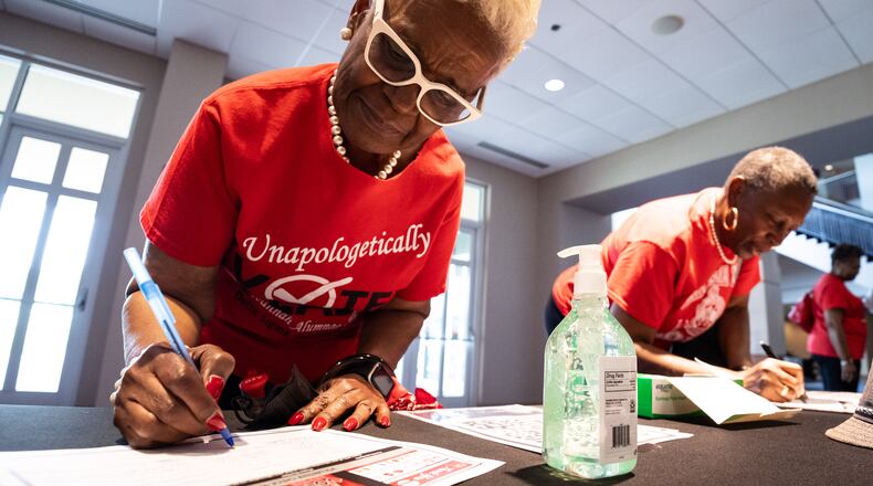 Elaine Shavers Campbell, the president of the Savannah Alumnae Chapter of Delta Sigma Theta Sorority Inc., writes down her information as a volunteer for a voter mobilization event at New Birth Missionary Baptist Church in Stonecrest, GA on Saturday, July 20, 2024. (Seeger Gray / AJC)