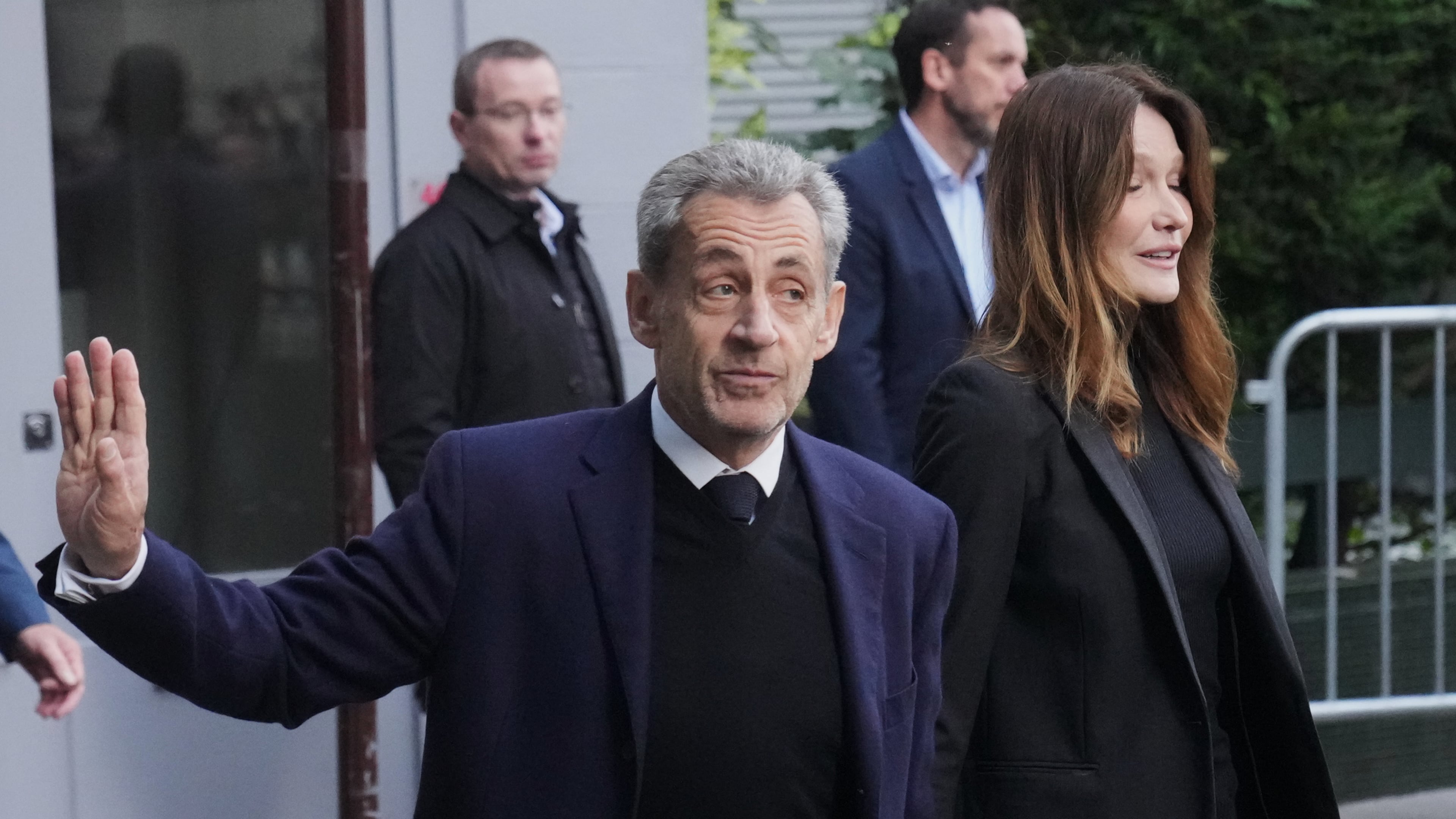 Former French President Nicolas Sarkozy and his wife Carla Bruni-Sarkozy leave their home Tuesday, Oct. 21, 2025 in Paris as Nicolas Sarkozy heads to prison to serve time for a criminal conspiracy to finance his 2007 election campaign with funds from Libya. (AP Photo/Thibault Camus)