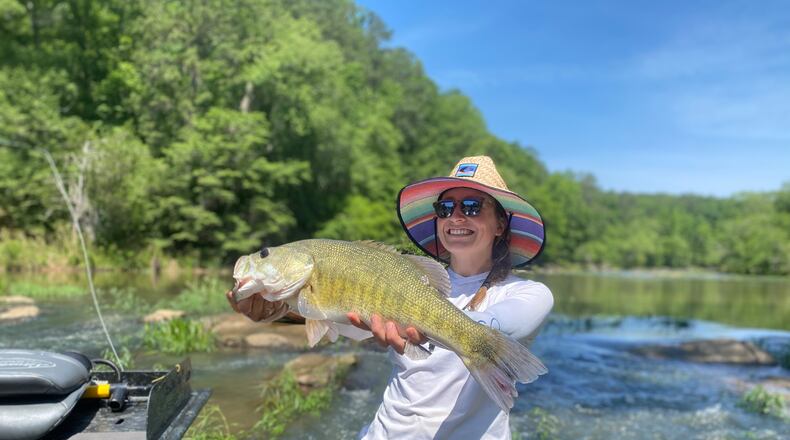 Jamie Rogers posts with a shoal bass caught on fly tackle in the spring of 2023 downstream of Yellow Jacket Shoals on the Flint River. Rogers is the daughter of Gordon Rogers, executive director of the Flint Riverkeeper. Photo courtesy of Rogers family.