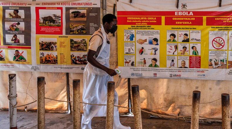 A health worker walks past Ebola warning and instruction posters at a temporary health clinic at the Mpondwe border crossing linking Uganda and the Democratic Republic of the Congo, Thursday, June 4, 2026. (AP Photo/Hajarah Nalwadda)