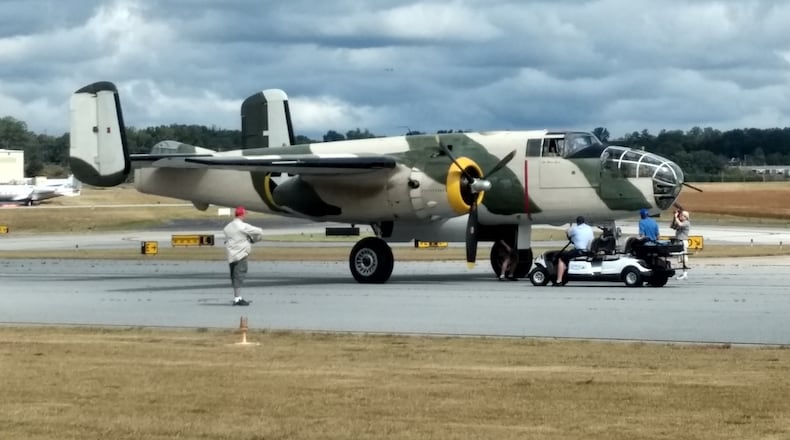 Vintage plane prepares for takeoff Saturday under sunshine and cloudy skies at DeKalb-Peachtree Airport. The plane was part of the Atlanta Warbirds Weekend. (Brian O'Shea / bposhea@ajc.com)