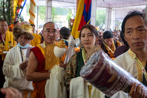 Exile Tibetans wait with ceremonial offerings for their spiritual leader the Dalai Lama at an event during which Tibetan exiles prayed for the Tibetan leader's longevity, a day before his 90th birthday, in Dharamshala, India, Saturday, July 5, 2025.(AP Photo/Ashwini Bhatia)