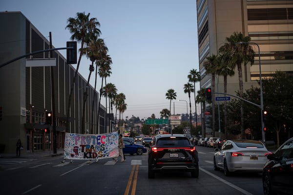 Protesters carry a large banner while demonstrating against the closure of the trans youth clinic at Children's Hospital Los Angeles, Thursday, July 3, 2025, in Los Angeles. (AP Photo/Jae C. Hong)