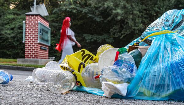 Piles of trash are overflowing Friday from cans outside the Fulton County Jail on Rice Street, where former President Donald Trump surrendered late Thursday night. (John Spink / John.Spink@ajc.com)