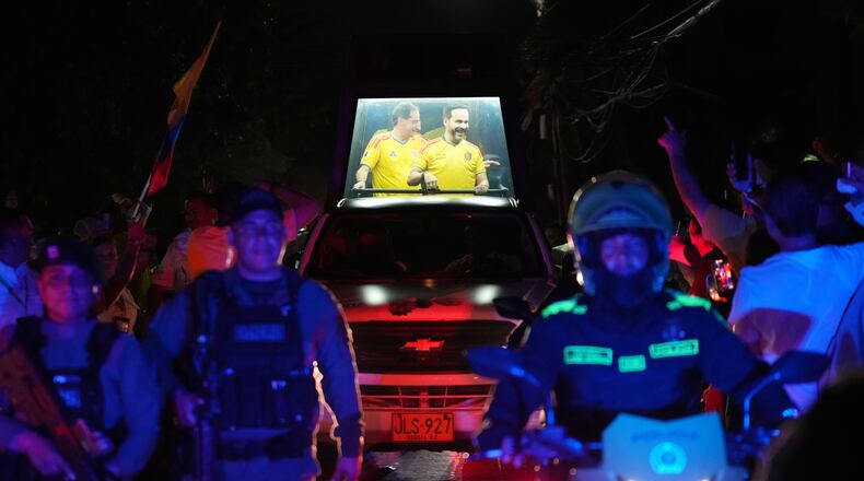 Presidential candidate Abelardo de la Espriella of the opposition Defenders of the Motherland movement and his vice-presidential running mate, Jose Manuel Restrepo, ride in a bulletproof booth toward a celebration rally after election results showed him leading in Barranquilla, Colombia, Sunday, June 21, 2026. (AP Photo/Rodrigo Abd)