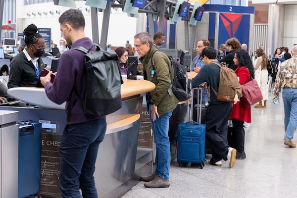 Passengers wait at a Delta check-in counter at the Hartsfield-Jackson Atlanta International Airport domestic terminal on Friday, Nov. 7, 2025. It was the first day of the Federal Aviation Administration cutting flight capacity at airports during the government shutdown. (Arvin Temkar/AJC)