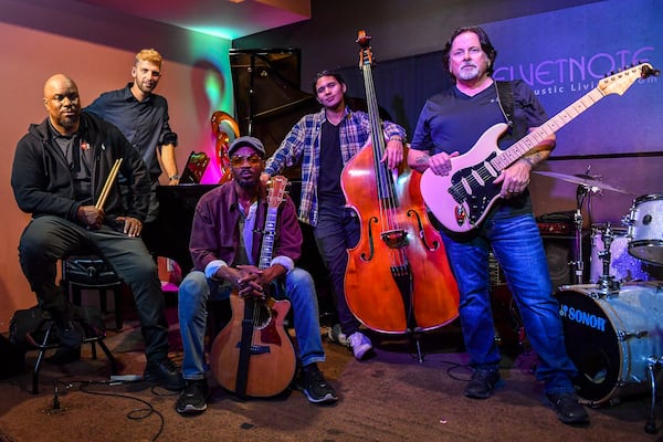 Pictured are most of the Niles Rivers Band members. Raheem Miles, in the front on the left, is no longer a member of the group. From left to right are Caleb Hensinger (back left), Niles Rivers, Chris Sanchez and Bill Hart. The musicians posed for a photo during the band's first rehearsal in November at The Velvet Note in Alpharetta. (Daniel Varnado/For the AJC)