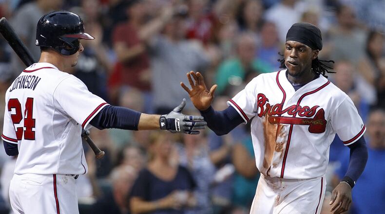 Cameron Maybin, right, celebrates with Kelly Johnson after scoring on a Nick Markakis double against the Chicago Cubs on July 17. (AP Photo/Brett Davis)