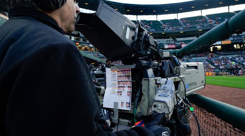 FILE - A sheet showing Boston Red Sox players photos hangs from a camera as a broadcast operator works during the first inning of a baseball game between the Baltimore Orioles and the Red Sox, Monday, April 24, 2023, in Baltimore, Md. (AP Photo/Julio Cortez, File)