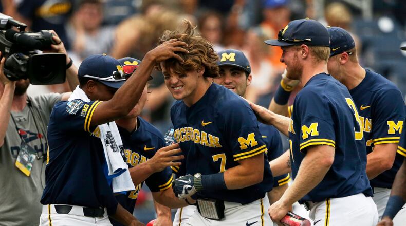 Michigan's Jesse Franklin (middle) is greeted by teammates after he hit a solo home run in the College World Series on June 17, 2019. (AP Photo/Nati Harnik)