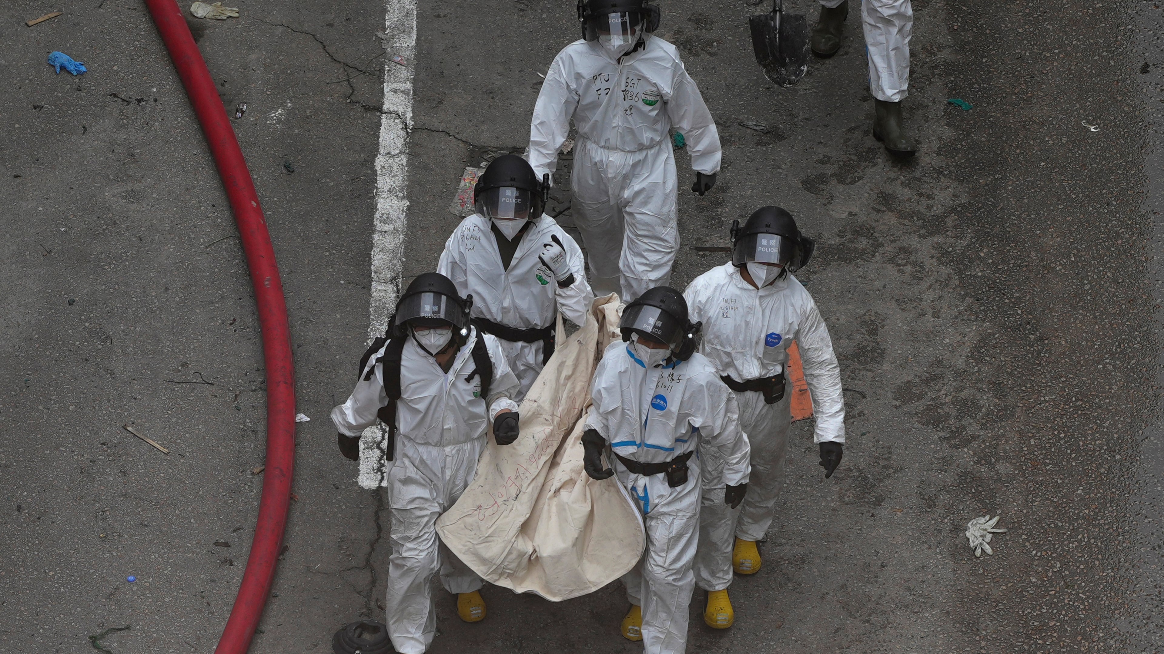 Police remove what appears to be a body bag from the site of a deadly Wednesday fire at Wang Fuk Court, a residential estate in the Tai Po district of Hong Kong's New Territories on Sunday, Nov. 30, 2025. (AP Photo/Ng Han Guan)