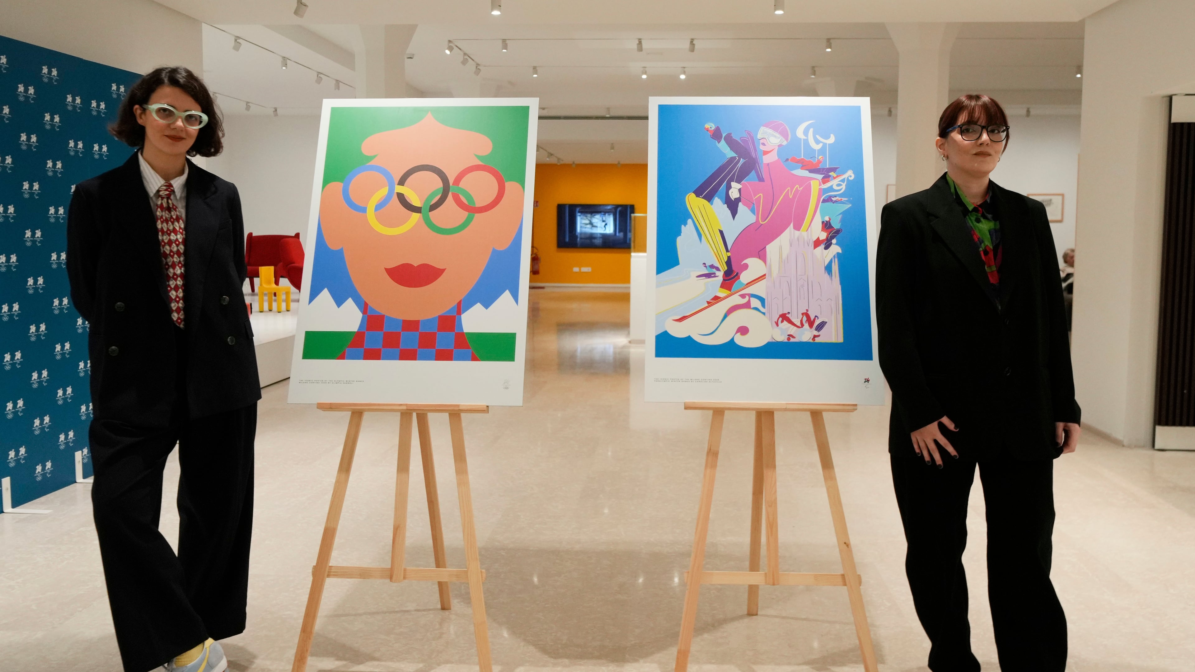 Artists Olimpia Zagnoli, left, and Carolina Altavilla pose next to Milano-Cortina 2026 Winter Olympics iconic posters presented during a press conference at Milan's Triennale permanent exhibition in Milan, Italy, Wednesday, Oct. 22, 2025. (AP Photo/Luca Bruno)