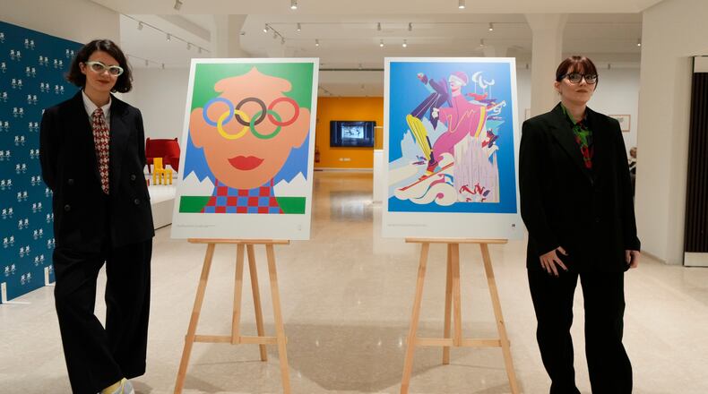 Artists Olimpia Zagnoli, left, and Carolina Altavilla pose next to Milano-Cortina 2026 Winter Olympics iconic posters presented during a press conference at Milan's Triennale permanent exhibition in Milan, Italy, Wednesday, Oct. 22, 2025. (AP Photo/Luca Bruno)