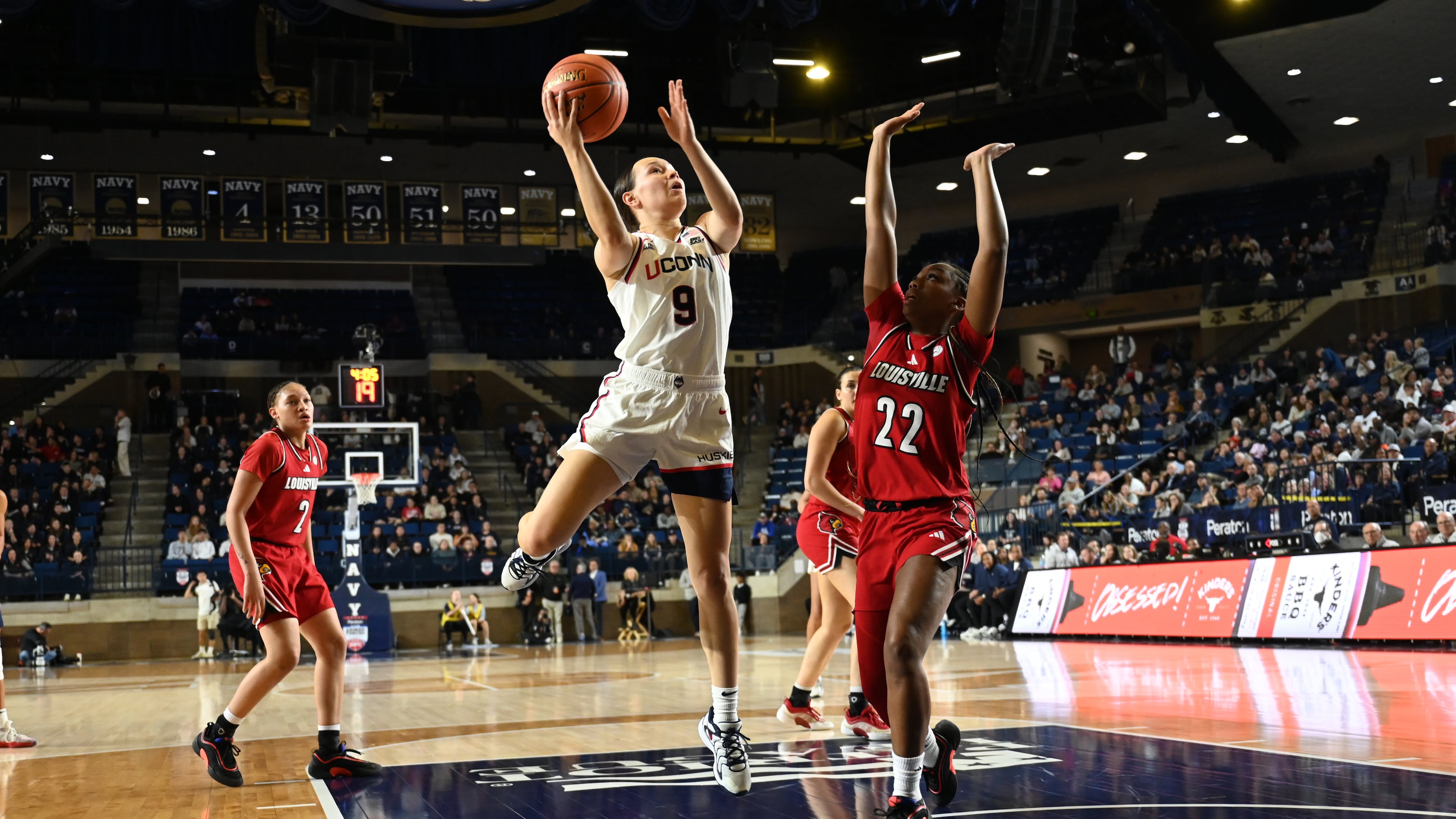 UConn guard Kayleigh Heckel (9) shoots as Louisville guard Tajianna Roberts (22) defends during the first half of a NCAA college basketball game, Tuesday, Nov. 4, 2025, in Annapolis, Md. (AP Photo/Gail Burton)