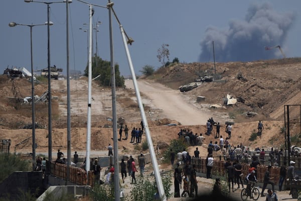 FILE - Israeli army tanks are seen positioned as smoke rises in the background in southern Gaza, as seen from a humanitarian aid distribution center operated by the U.S.-backed Gaza Humanitarian Foundation, approved by Israel, in Khan Younis, southern Gaza Strip, on Thursday, May 29, 2025. (AP Photo/Abdel Kareem Hana,File)
