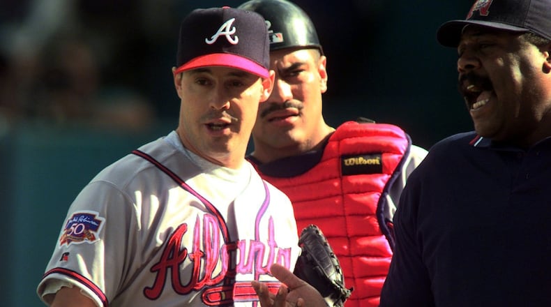 With catcher Eddie Perez listening in (background), Braves starting pitcher Greg Maddux argues a call with umpire Eric Gregg (right) during NLCS Game 5 Oct. 12, 1997, against the Florida Marlins in Miami. (W. A. Bridges, Jr./AJC)