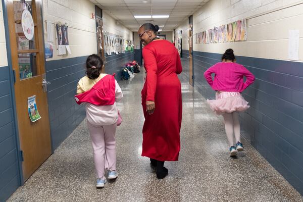 Oak Grove Elementary Principal Valarie Kennedy talks with students as she walks down a hallway at the DeKalb County school in March. (Ben Gray for the AJC)