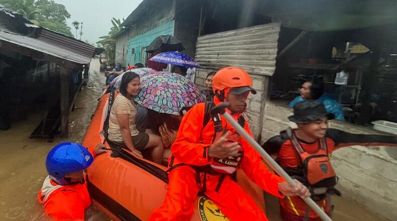 In this photo released by the Indonesian National Search and Rescue Agency (BASARNAS), rescuers on a rubber boat evacuate residents from their flooded home in North Sumatra province, Indonesia Tuesday, Nov. 25, 2025. (BASARNAS via AP)