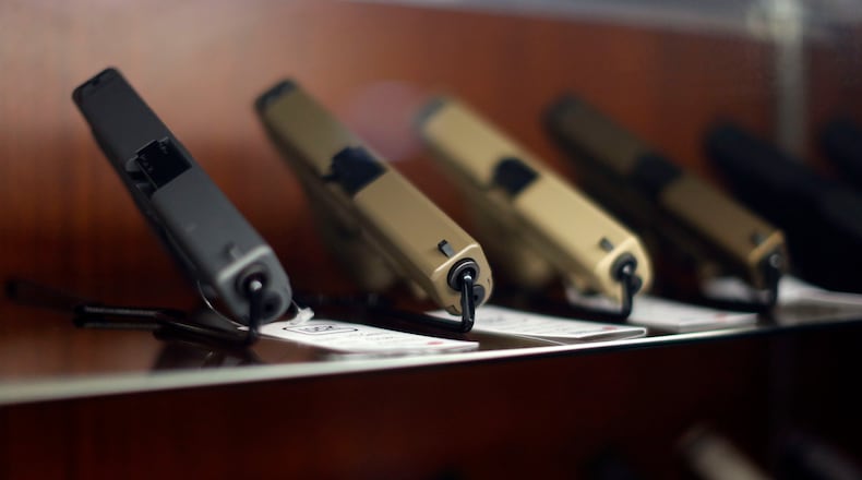 Glock 9mm pistols in an assortment of colors in a display cabinet are shown in a 2016 file photo. Patrons shop for guns and use the shooting range at Sharpshooters USA in Roswell. The store sells firearms, and has an indoor shooting range & training center. BOB ANDRES / BANDRES@AJC.COM