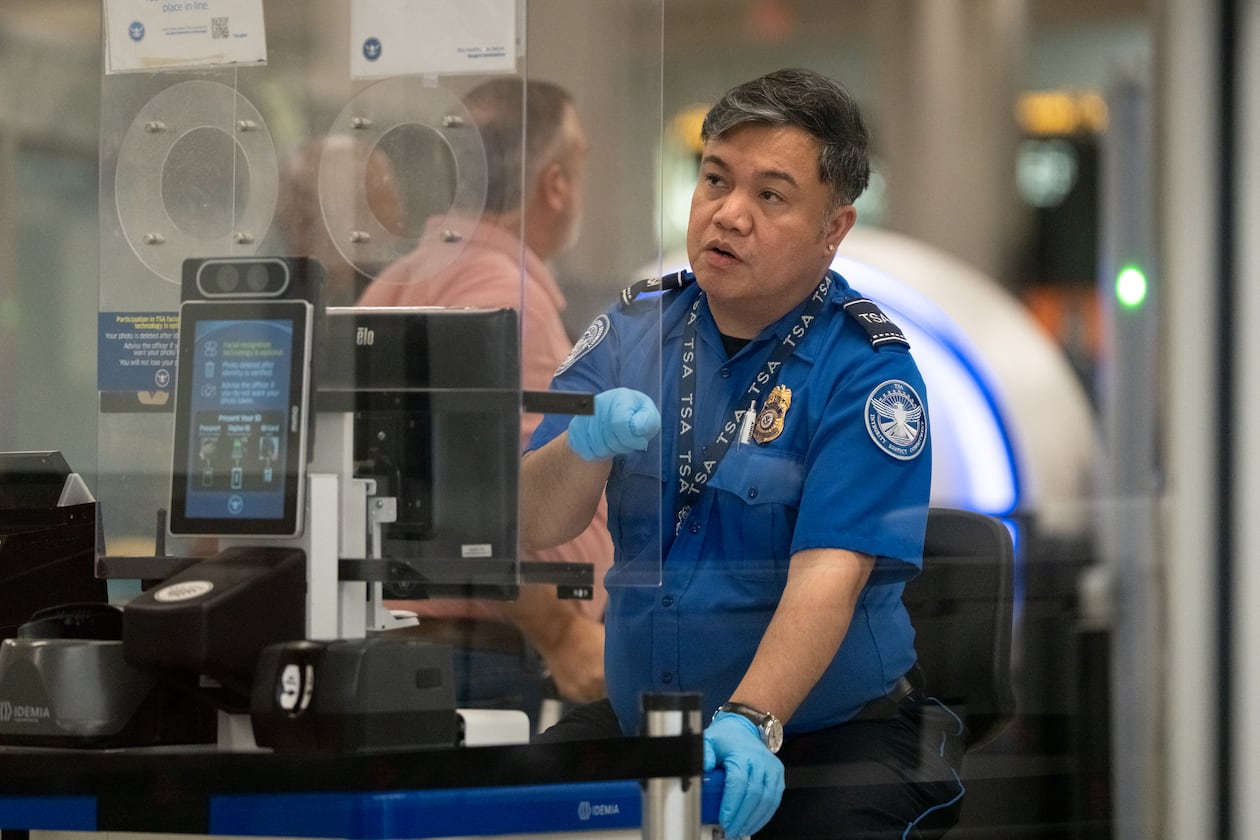 A Transportation Security Administration officer checks the identification of travelers at Hartsfield-Jackson Atlanta International Airport on Wednesday, Oct. 1, 2025 (Ben Hendren for the AJC)