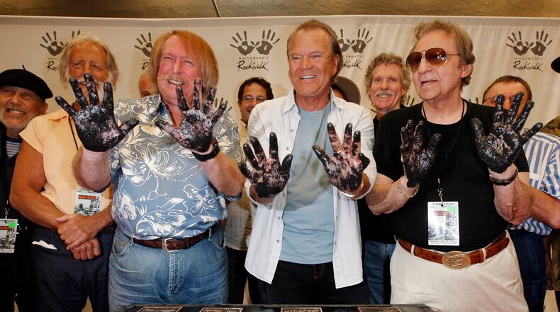 Don Randi, left, Glen Campbell, center, and Hal Blaine, representing session musicians known as The Wrecking Crew, hold up their hands after placing them in the cement following the induction ceremony for Hollywood's RockWalk in Los Angeles, Wednesday June 25, 2008. (AP Photo/Kevork Djansezian)