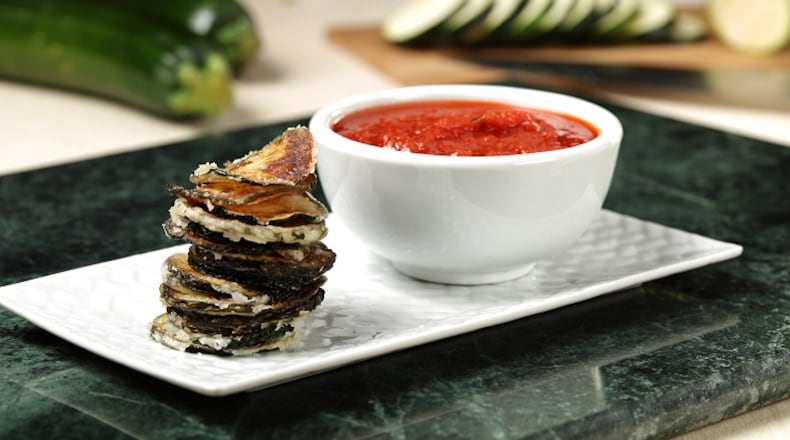 Fresh slices of zucchini, coated with a light dusting of potato starch, transform into crispy chips when deep fried. Marinara sauce makes a zesty dip. (Abel Uribe/Chicago Tribune/TNS)