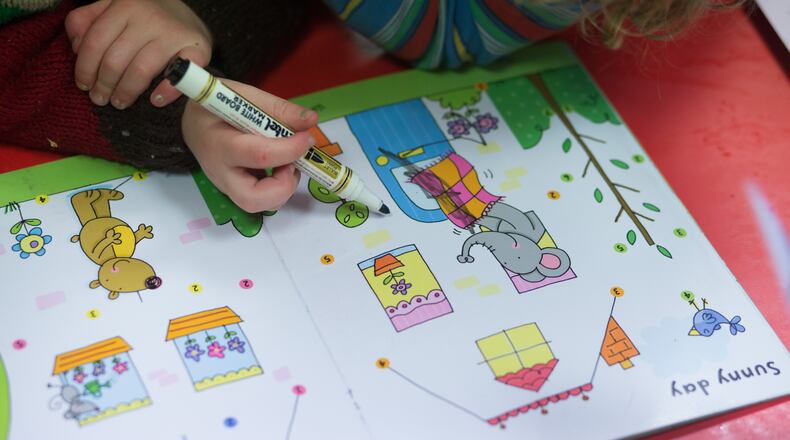 A young girl draws at a playgroup for pre-school aged children. (Photo by Matt Cardy/Getty Images)