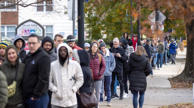 Voters wait in a line stretching down the road from Joan P. Garner Library at Ponce de Leon on the last day of early voting in metro Atlanta on Friday, December 2, 2022.   (Arvin Temkar / arvin.temkar@ajc.com)