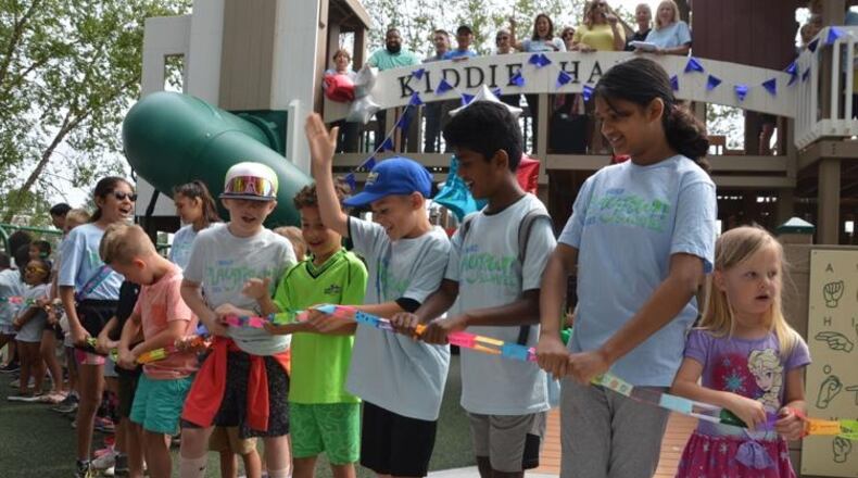 Several kids line up to break a paper chain to officially open the new PlayTown Suwanee playground at Town Center on Main Park. (Photo Courtesy of Curt Yeomans)