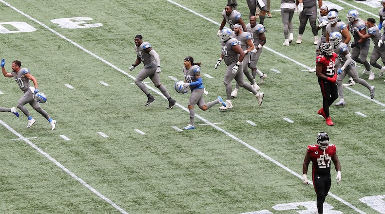 102520 Atlanta: Falcons players Grady Jarrett (bottom right) and Steven Means walk off the field dejected as Detroit Lions kicker Matt Prater (far left) is chased off the field by celebrating teammates after making the extra-point attempt to beat the Falcons 23-22 Sunday, Oct. 25, 2020, at Mercedes-Benz Stadium in Atlanta. (Curtis Compton / Curtis.Compton@ajc.com)