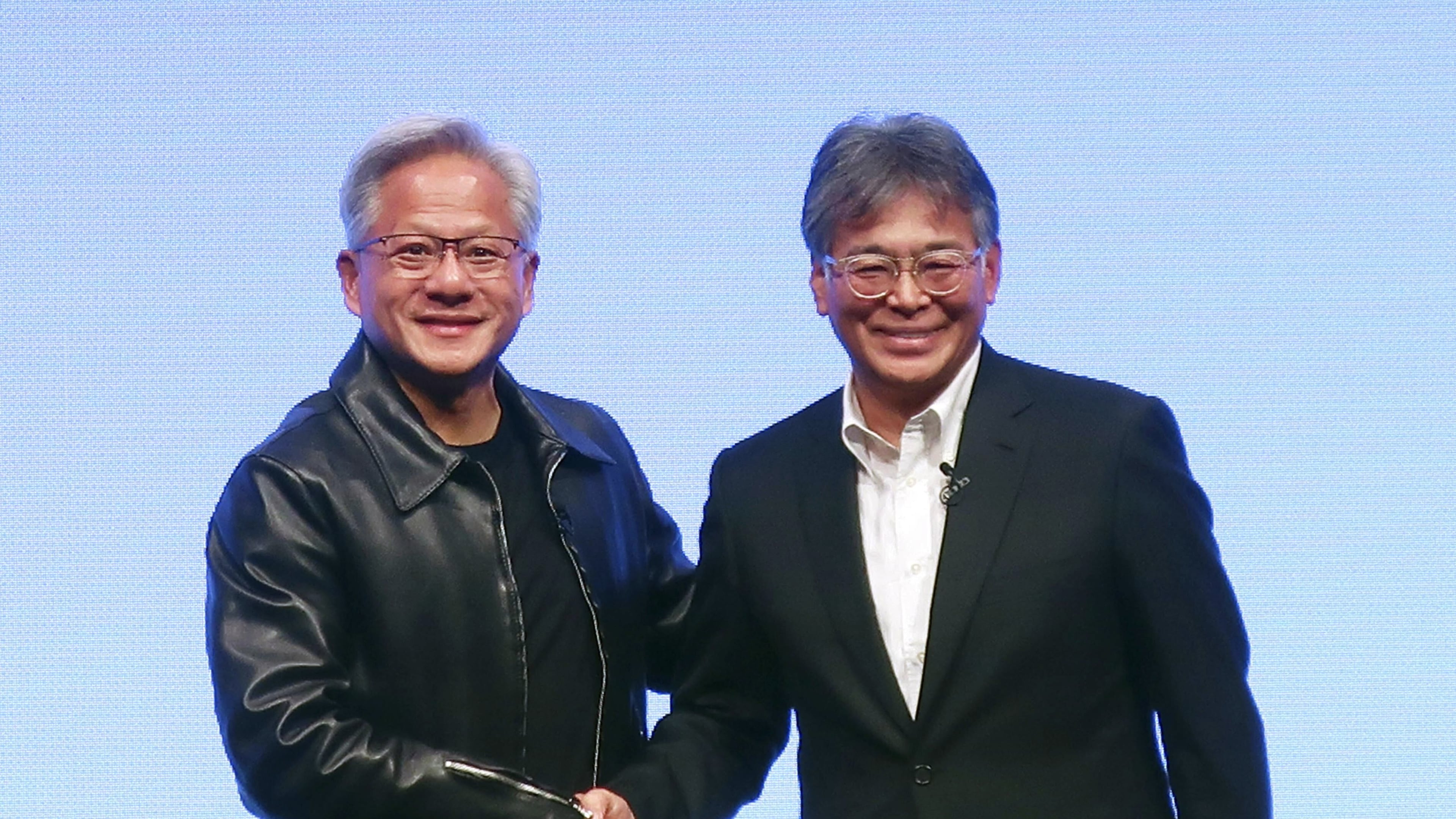 Nvidia Chief Executive Jensen Huang, left, and Fujitsu Chief Executive Takahito Tokita shake hands during an announcement in Tokyo Friday, Oct. 3, 2025. (Kyodo News via AP)