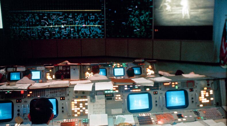 This July 20, 1969 photo made available by NASA shows the Mission Operations Control Room (MOCR) in the Mission Control Center (MCC), Building 30, during the Apollo 11 lunar extravehicular activity (EVA). The television monitor shows astronauts Neil A. Armstrong and Edwin E. Aldrin Jr. on the surface of the moon.