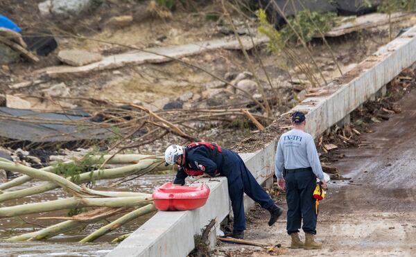 Members of the Texas A&M Task Force 1 Search & Rescue inspect the Cade Loop bridge along the Guadalupe River on Saturday, July 5, 2025, in Ingram, Texas. (AP Photo/Rodolfo Gonzalez)