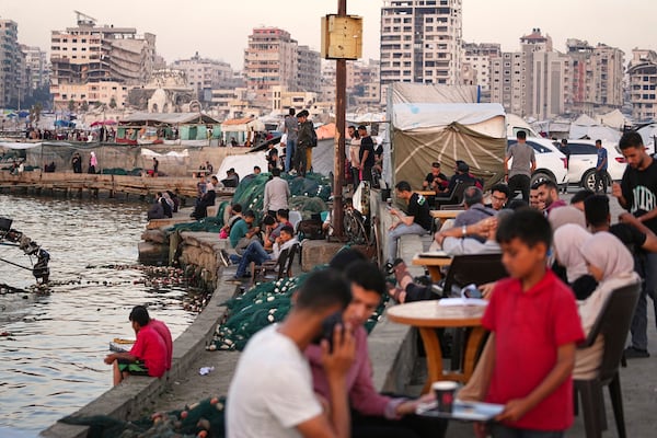 Palestinians spend time at the seafront next to a tent camp in the Gaza City port, Friday, June 13, 2025. (AP Photo/Jehad Alshrafi)