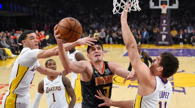 Atlanta Hawks forward Ersan Ilyasova, second from right, shoots as Los Angeles Lakers guard Lonzo Ball, left, guard Kentavious Caldwell-Pope, second from left, and center Brook Lopez defend during the first half of a basketball game, Sunday, Jan. 7, 2018, in Los Angeles. (AP Photo/Mark J. Terrill)