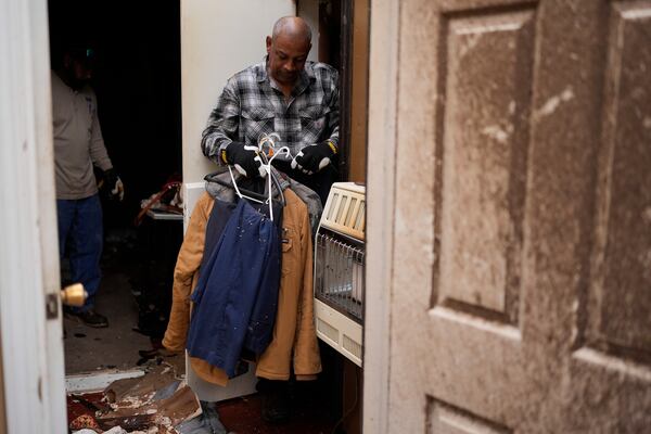 Willy Barns gathers cloths at his house after severe weather passed the area in Selma, Tenn., Thursday, April 3, 2025. (AP Photo/George Walker IV)