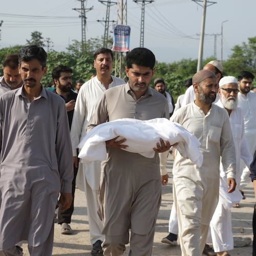 A man carries the body of a newborn for burial after the child died in a fire at a hospital in Islamabad, Pakistan, Wednesday, Aug. 26, 2026. (AP Photo/Ehsan Shahzad)