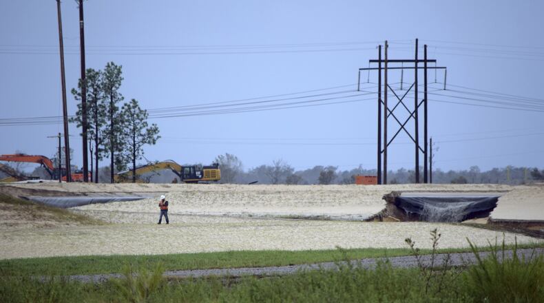 Gray water containing coal ask flows from a ruptured landfill at the L.V. Sutton Power Station in Wilmington, N.C., and flows toward Sutton Lake, near the Cape Fear River. (Kemp Burdette/Cape Fear River Watch via AP)