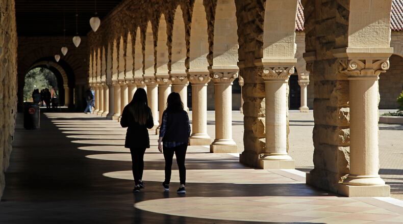FILE - Students walk through the Stanford University campus, March 14, 2019, in Santa Clara, Calif. (AP Photo/Ben Margot, File)