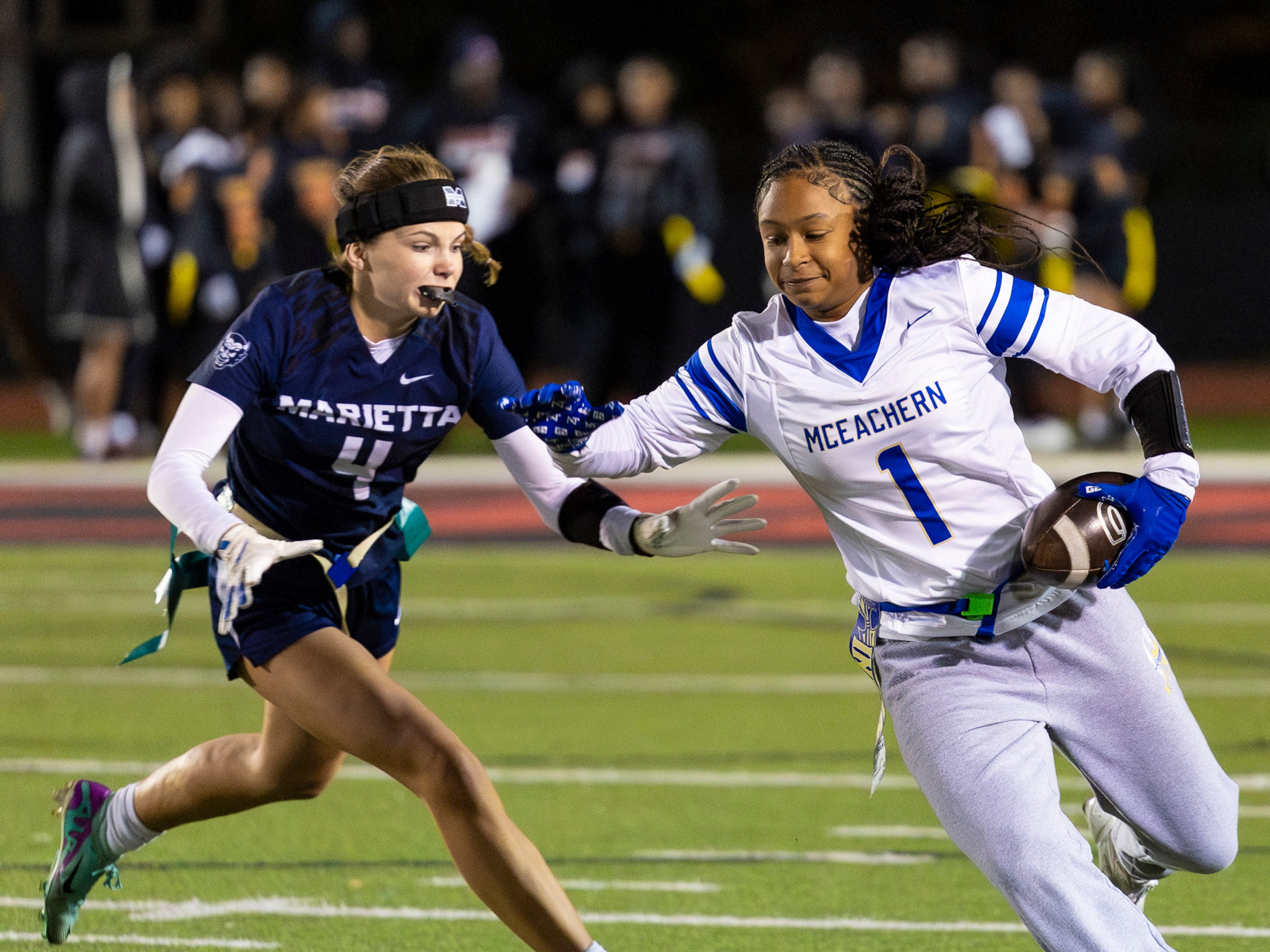 McEachern wide receiver Michala Butler (right) runs alongside Marietta's Joy Gross (4) in a flag football game against McEachern at Osborne High School in Marietta, GA on Monday, November 17th, 2025. (Oscar Guevara Saenz for the AJC)