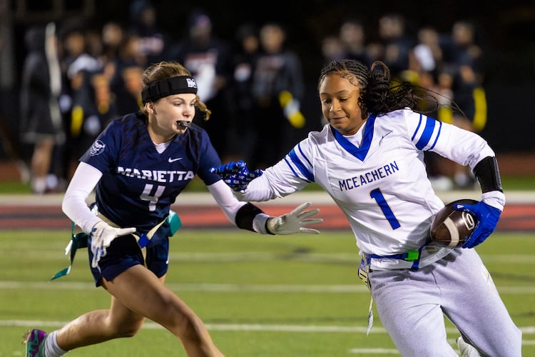 McEachern wide receiver Michala Butler (right) runs alongside Marietta's Joy Gross (4) in a flag football game against McEachern at Osborne High School in Marietta, GA on Monday, November 17th, 2025. (Oscar Guevara Saenz for the AJC)