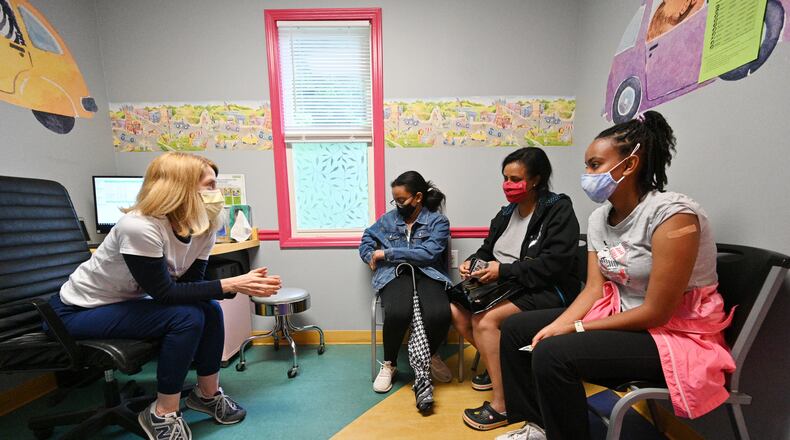 Dr. Debby Pollack, left, talks to Miriam Araya, right, 15, and her mother Betty Kidanu and sister Melina Araya, 11, after Miriam received a first dose of the Pfizer-BioNTech vaccine at Dekalb Pediatric Center last week. More than a thousand patients, most of them 12-15 years old, had seized the opportunity to get a shot of the Pfizer-BioNTech vaccine at the clinic, which is partnering with the local school system to vaccinate students. (Hyosub Shin / Hyosub.Shin@ajc.com)