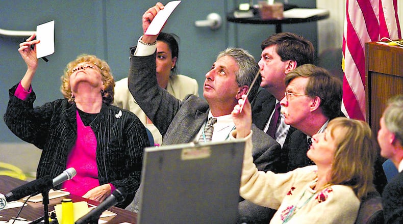 Surrounded by attorneys for the Democratic and Republican parties, the Palm Beach County, Florida, election canvassing board examines questionable ballots in the county Emergency Operations Center, where the hand count of all Palm Beach County ballots is taking place in this photo from November 24, 2000. (Lannis Waters/Palm Beach Post/TNS)