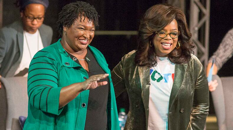 Oprah Winfrey and Stacey Abrams greet a crowd gathered for a town hall conversation at the Cobb Civic Center on Nov. 1, 2018.